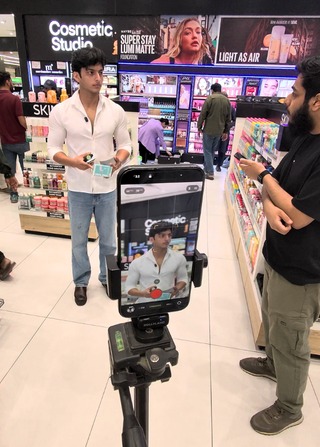 Filming a creator on a tripod-mounted phone in a cosmetics store